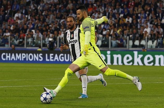 Brankář Monaka Daniel Subašic odkopává míč před Gonzalem Higuainem z Juventusu.