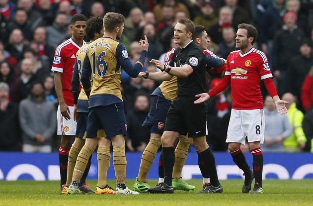 Aaron Ramsey (16) z Arsenalu a Mata (8) z Manchester United při utkání anglické ligy, mezi nimi sudí Craig Pawson.