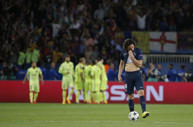 Smutný útočník Paris St. Germain Edinson Cavani. V pozadí radující se fotbalisté Barcelony.