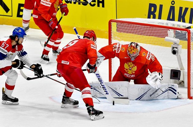 Michael Frolík (vlevo) se snaží ohrozit ruského brankáře Andreje Vasilevského, uprostřed brání Dmitrij Orlov.
