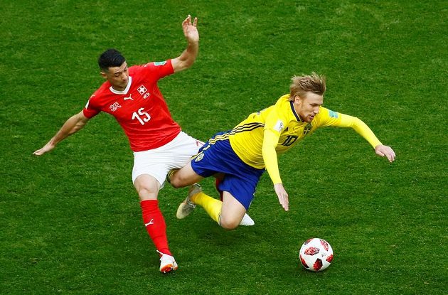 Švéd Emil Forsberg padá po souboji se švýcarským záložníkem Blerimim Dzemailim.