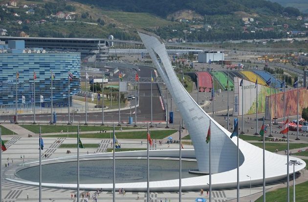 Po průjezdu první zatáčkou se jezdci F1 dostanou na okruhu v Soči na rovinku vedoucí k pylonu, na němž plál olympijský oheň. Vlevo vystupuje krasobruslařská hala Iceberg.