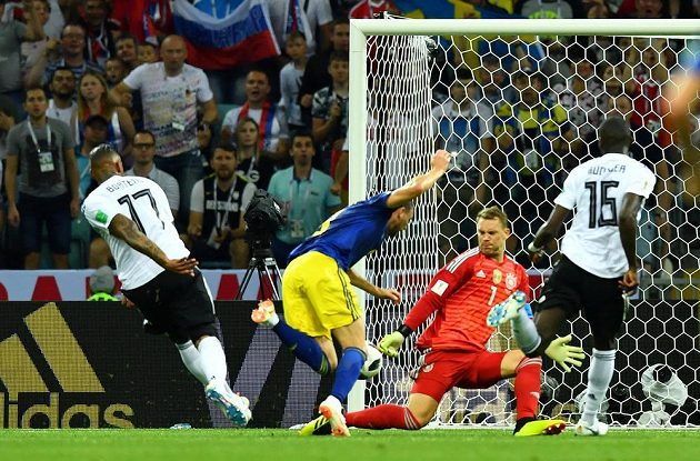 Německý obránce Jerome Boateng (vlevo) sráží v pokutovém území unikajícího Marcuse Berga. Polský sudí však zákrok jako nedovolený neposoudil.