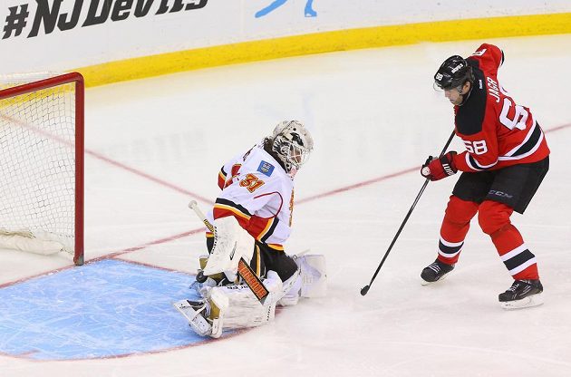 Brankář Calgary Karri Rämö likviduje šanci Ďáblů. Vpravo je útočník New Jersey Jaromír Jágr.