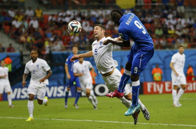 Italský forvard Mario Balotelli (vpravo) hlavičkuje míč do branky Anglie, Gary Cahill jej ubránit nedokázal.