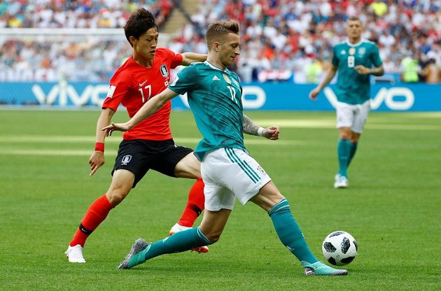 Německý reprezentant Marco Reus se snaží odehrát míč před dotírajícím Korejcem I Če-Songem v utkání mistrovství světa.