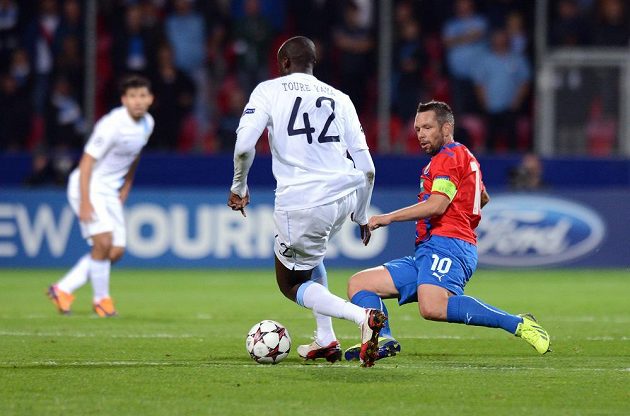 Plzeňský záložník Pavel Horváth (vpravo) se skluzem snaží vypíchnout míč středopolaři Manchesteru City Yayovi Tourému během zápasu Ligy mistrů.