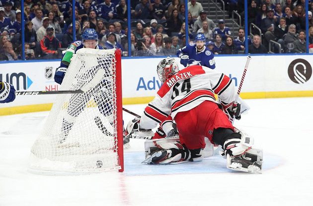 Brankář Caroliny Hurricanes Petr Mrázek je překonaný, v utkání NHL na ledě Tampy Bay mu dal gól jeho krajan Ondřej Palát (18).
