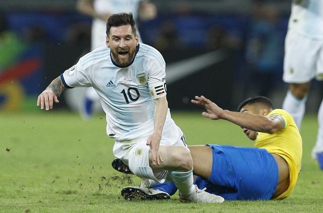 Argentinský fotbalový reprezentant Lionel Messi padá po souboji s Brazilcem Casemirem.