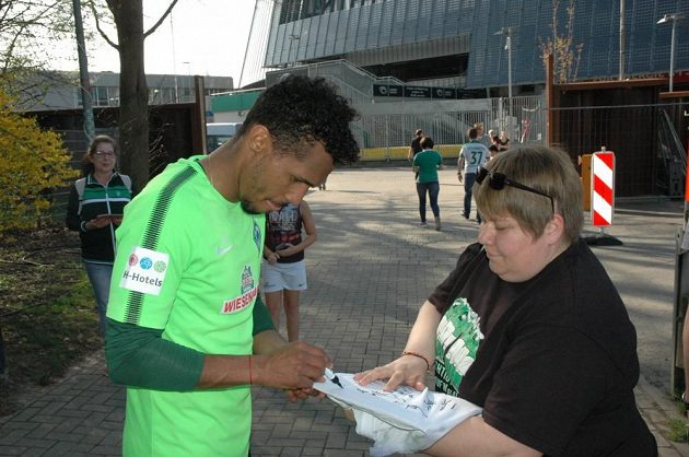 Obránce Werderu Brémy Theodor Gebre Selassie se po tréninku podepisuje fanouškům.