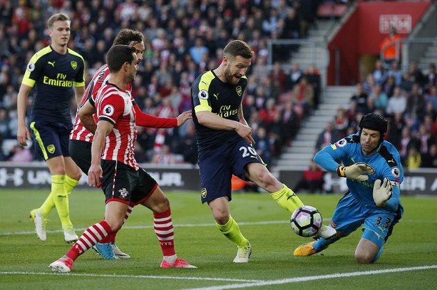 Stoper Arsenalu Shkodran Mustafi odkopává míč před brankářem Petrem Čechem a dotírajícími hráči Southamptonu.