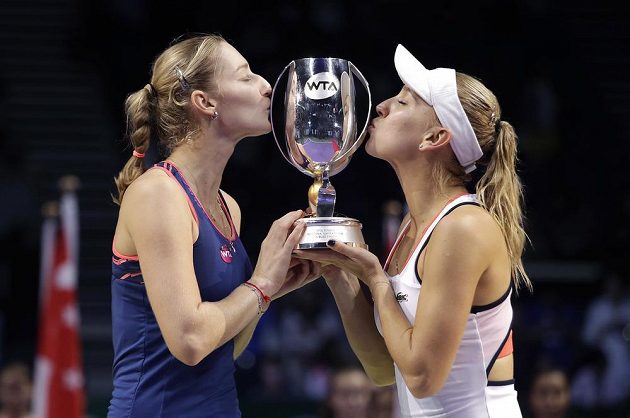 Ruská dvojice Jekatěrina Makarovová a Jelena Vesninová líbají trofej pro vítězky Turnaje mistryň.