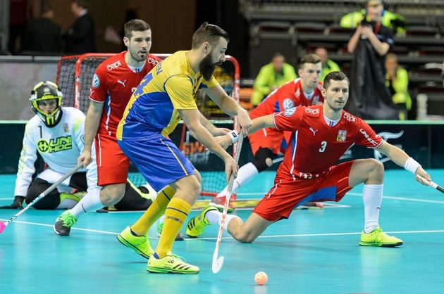 Čeští florbalisté Jan Jelínek (vlevo) a Daniel Šebek v obranném pokleku proti Thomasovi Holmgrenovi.