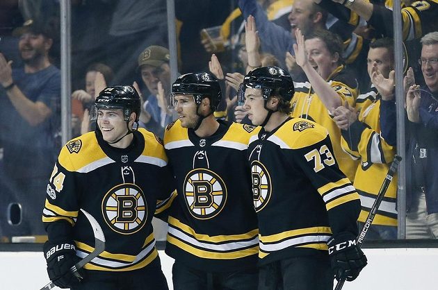 David Krejčí (uprostřed) se raduje z trefy proti Vancouveru se spoluhráči z Bostonu Jakem DeBruskem (vlevo) a Charliem McAvoyem.