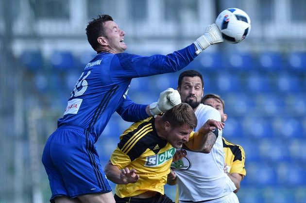 Brankář Jan Laštůvka (vlevo) z Karviné vyráží míč před Magerou z Mladé Boleslavi.