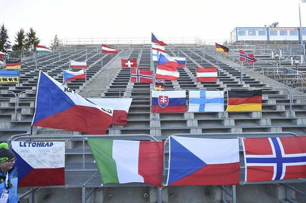 Lidé z organizačního výboru rozvěsili před sprintem vlajky na prázdné tribuně biatlonového areálu v Novém Městě na Moravě.