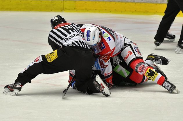 Čárový rozhodčí Ondřej Malý se snaží odtrhnout Anthonyho Camaru z Pardubic a Libora Zábranského z Karlových Varů. Oba dostali dvouminutový trest.