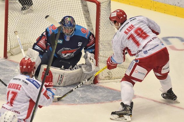 Rostislav Marosz (vlevo) a Cory Kane z Třince před chomutovským brankářem Jánem Lacem.