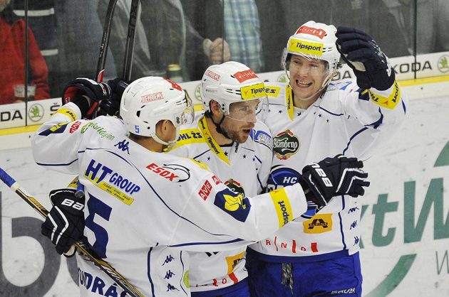 Hokejisté Komety Brno zleva Tomáš Vondráček, Jakub Koreis a Vilém Burian se radují z druhého gólu na ledě Boleslavi.
