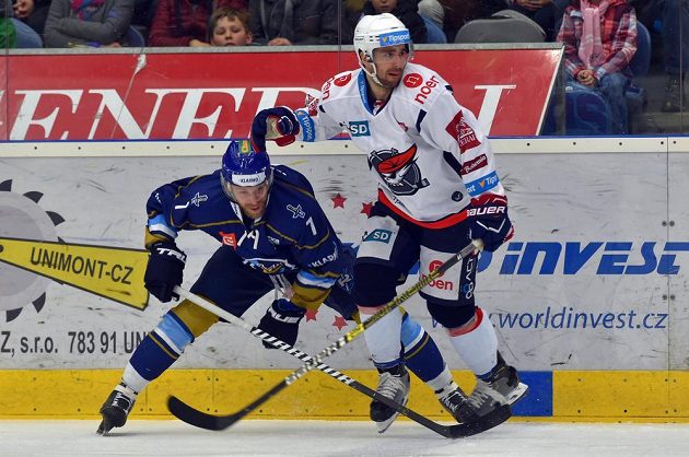 Kladenský hokejista Petr Hořava a Brett Flemming z Chomutova v akci během utkání baráže o extraligu.