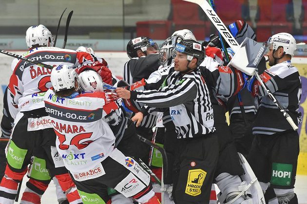 Čárový rozhodčí Ondřej Malý se snaží odtrhnout Anthonyho Camaru z Pardubic a Libora Zábranského z Karlových Varů. Oba dostali dvouminutový trest.