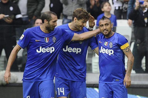 Fotbalisté Juventusu Giorgio Chiellini (vlevo) a Fernando Llorente gratulují Arturo Vidalovi (vpravo) k brance v utkání proti Palermu.