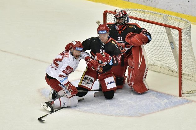 Vladimír Dravecký z Třince (vlevo) a hráči Hradce Maris Bičevskis a brankář Jaroslav Pavelka v akci během extraligového utkání.