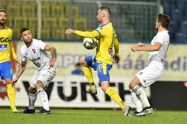 Martin Fillo (vlevo v bílém) z Baníku Ostrava, teplický Pavel Moulis s míčem a vpravo střelec gólu Adam Jánoš z Baníku Ostrava během utkání nejvyšší fotbalové soutěže.