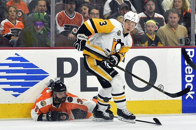 Český zadák Radko Gudas (3) z Philadelphie se snaží i vleže sebrat puk obránci Pittsburghu Olli Määttämu (3).