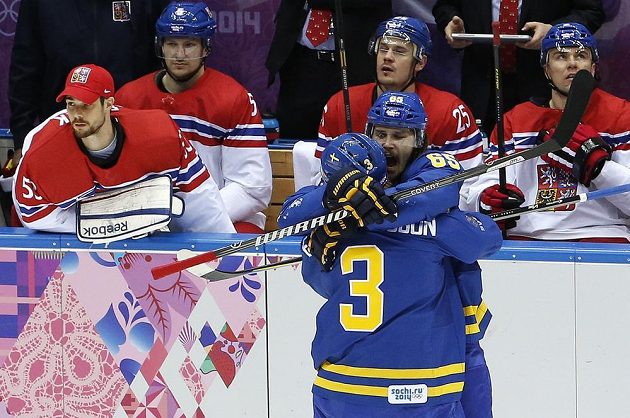 Erik Karlsson (č 65) oslavuje gól se spoluhráčem Oliverem Ekmanem-Larssonem před smutnou českou střídačkou.