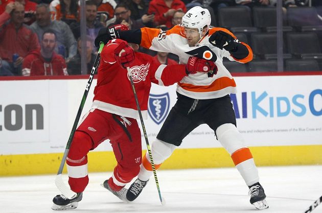 Obránce Detroitu Dennis Cholowski (vlevo) v tvrdém souboji s Jamesem van Riemsdykem z Philadelphie.