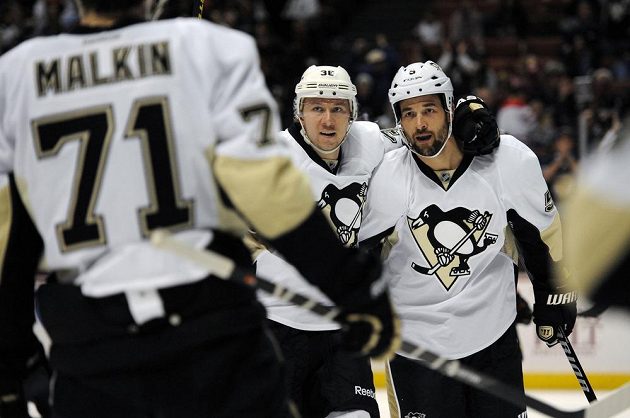 Obránce Tučňáků Deryk Engelland (vpravo) oslavuje se spoluhráči gól do sítě Anaheimu.