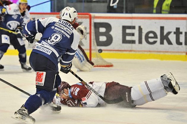 Sparťanský forvard Tomáš Rolinek (dole) se snaží obětavým zákrokem zblokovat střelu Branislava Kubky z Plzně.