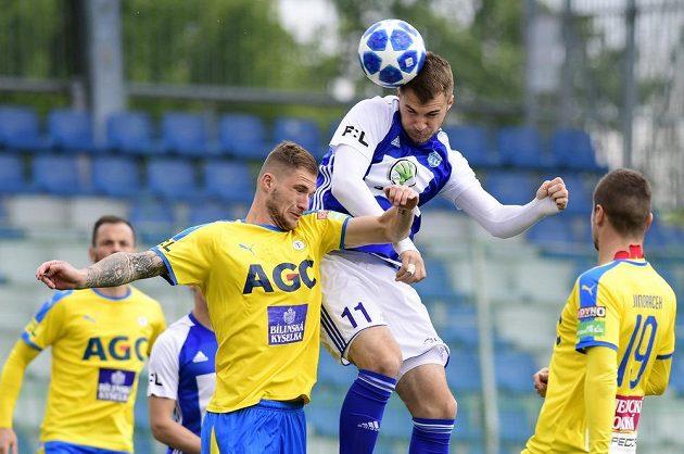 Pavel Čmovš z Teplic (vlevo) se snaží ve vzdušném souboji zabránit v zakončení mladoboleslavskému snajprovi Nikolaji Komličenkovi z Boleslavi během utkání semifinále skupiny o Evropu.
