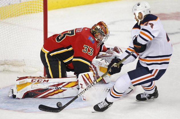 Český brankář David Rittich při úspěšném zákroku proti Zacku Kassianovi z Edmontonu.