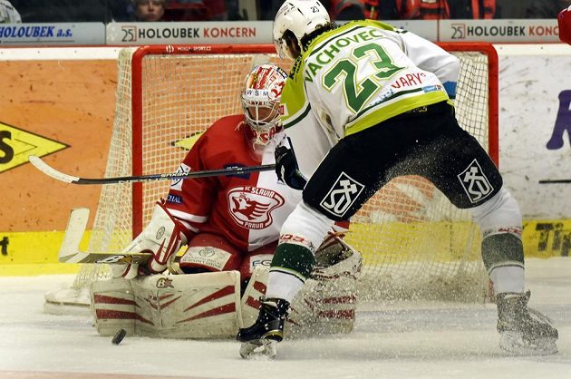 Karlovarský útočník Michal Vachovec se snaží překonat slávistického brankáře Alexandra Hyláka v zápase 6. kola baráže o extraligu.