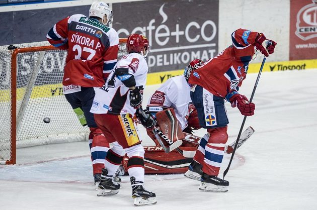 Pardubický útočník Tomáš Rolinek (vpravo) tečuje puk do sítě hradeckého brankáře Jaroslava Pavelky. Přihlížejí Petr Sýkora (vlevo) z Dynama a Petr Koukal z Hradce.