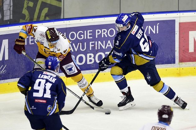 Utkání 11. kola baráže o hokejovou extraligu. O kotouč bojují jihlavský Josef Skořepa (vlevo) a Jurij Repe z Kladna. Akci sleduje Repeho spoluhráč Martin Lenďák.