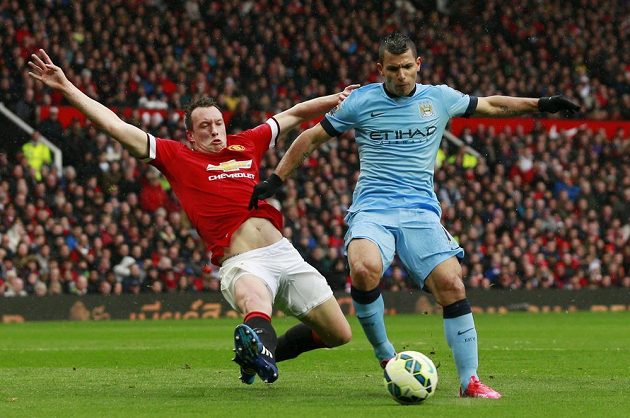 Phil Jones z Manchesteru United se skluzem snaží odebrat míč útočníkovi Manchesteru City Sergio Agüerovi.