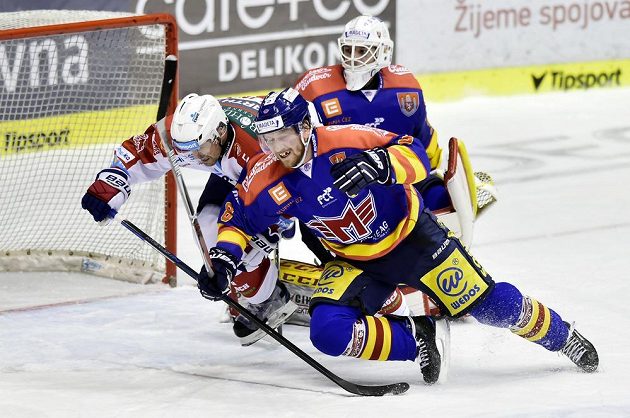 Tomáš Rolinek z Pardubic (vlevo) v souboji s Filipem Novákem z Českých Budějovice během utkání 1. kola baráže o hokejovou extraligu. Vše sleduje brankář Motoru Petr Kváča.
