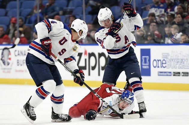 Útočník české reprezentace do 20 let Filip Chytil v sevření dvou amerických protihráčů v duelu o bronz na MS v Buffalu.