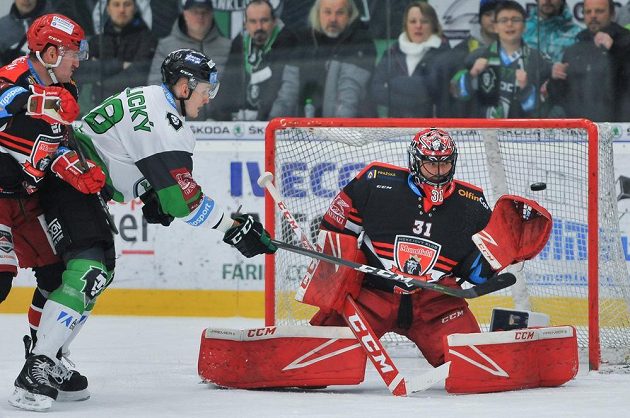 Brankář Hradce Králové Jaroslav Pavelka inkasoval v Mladé Boleslavi během první třetiny tři branky. Tentokrát ale stihl zasáhnout. Situaci sledují Pavol Skalický z Mladé Boleslavi a Tomáš Linhart z Hradce Králové.