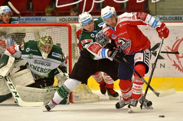 Pardubický forvard Lukáš Nahodil (vpravo) v souboji o puk s karlovarský bekem Tomášem Dujsíkem, vše pozoroval brankář David Honzík (vlevo).