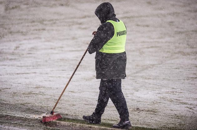 Pořadatel uklízí sníh na zasněžené Julisce před utkáním 19. kola Synot ligy mezi Duklou a Spartou, které nakonec bylo odloženo.