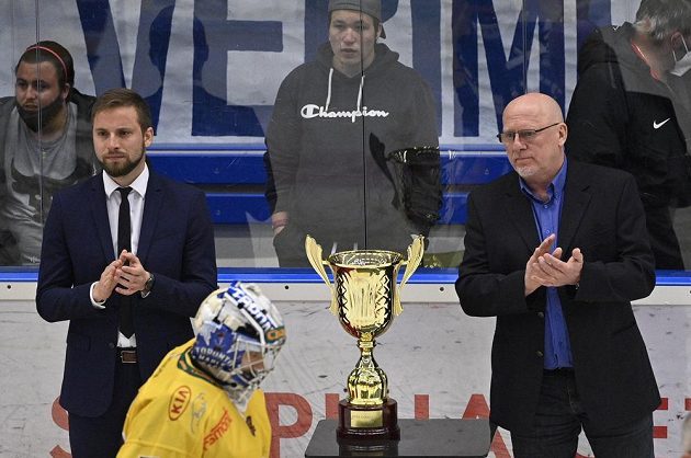Jihlavský brankář Maxim Žukov po prohraném utkání smutně projíždí kolem poháru pro vítěze první ligy. Vpravo je šéf soutěže Pavel Setikovský.