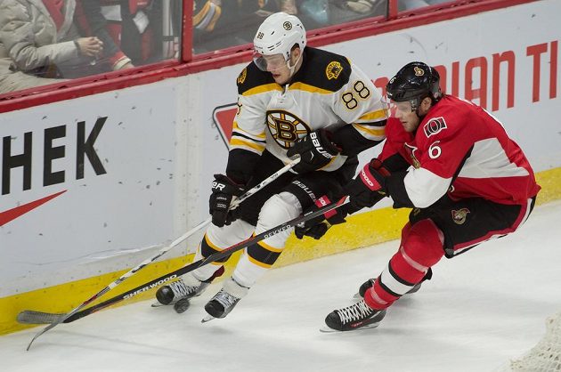 Český útočník David Pastrňák (88) z Bostonu je bráněn Bobbym Ryanem (6) z Ottawy v zápase NHL.