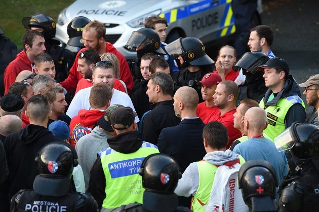 Trenér Brna Svatopluk Habanec (uprostřed v černé košili) hovoří před stadionem s fanoušky Brna mezi policejním kordonem a členy antikonfliktního týmu po prohraném utkání v Olomouci.