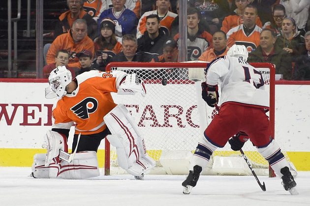 Gólman Philadelphia Flyers Petr Mrázek, před jeho branku najíždí Arťjom Panarin z Columbusu.
