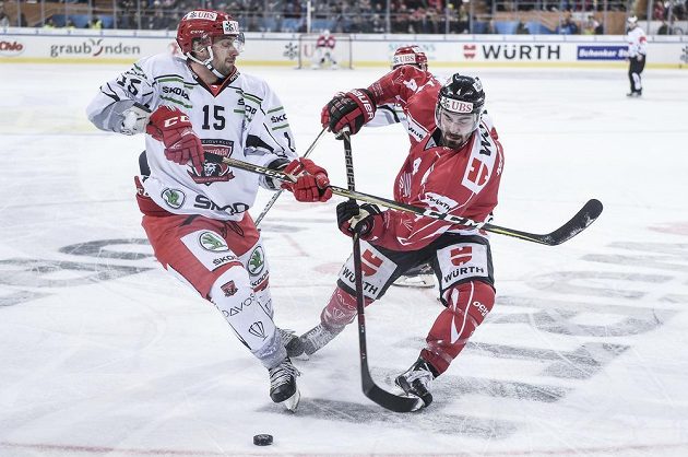 Blaž Gregorc (vlevo) z Hradce bojuje o puk s Brandonem Hickeym z kanadského výběru.