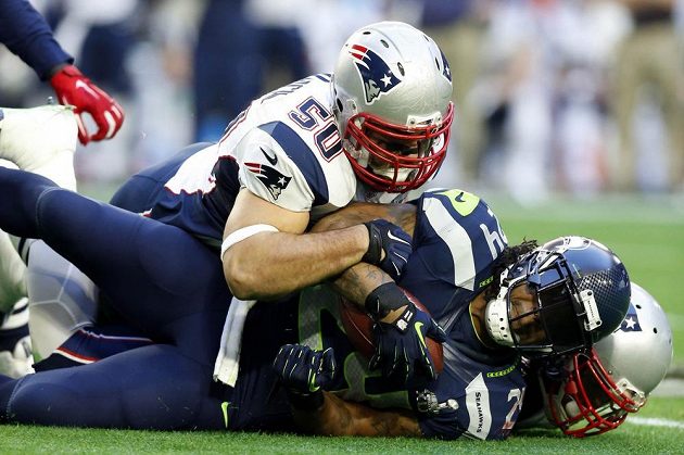 Running back Marshawn Lynch (dole) "v péči" Roba Ninkoviche z New England Patriots.